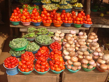 Marktstand mit Tomaten, Zwiebeln und Okraschoten