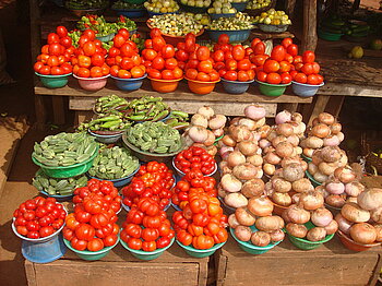 Marktstand mit Tomaten, Zwiebeln und Okraschoten