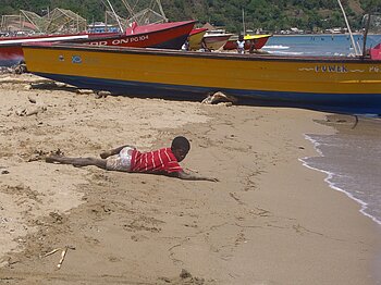 Kind am Strand von Jamaika