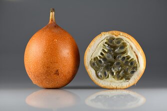 Orangene Frucht mir schwarzen Kernen