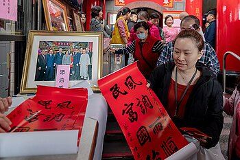 Frau kauft rotes Papier zum Chinesischen Neujahr
